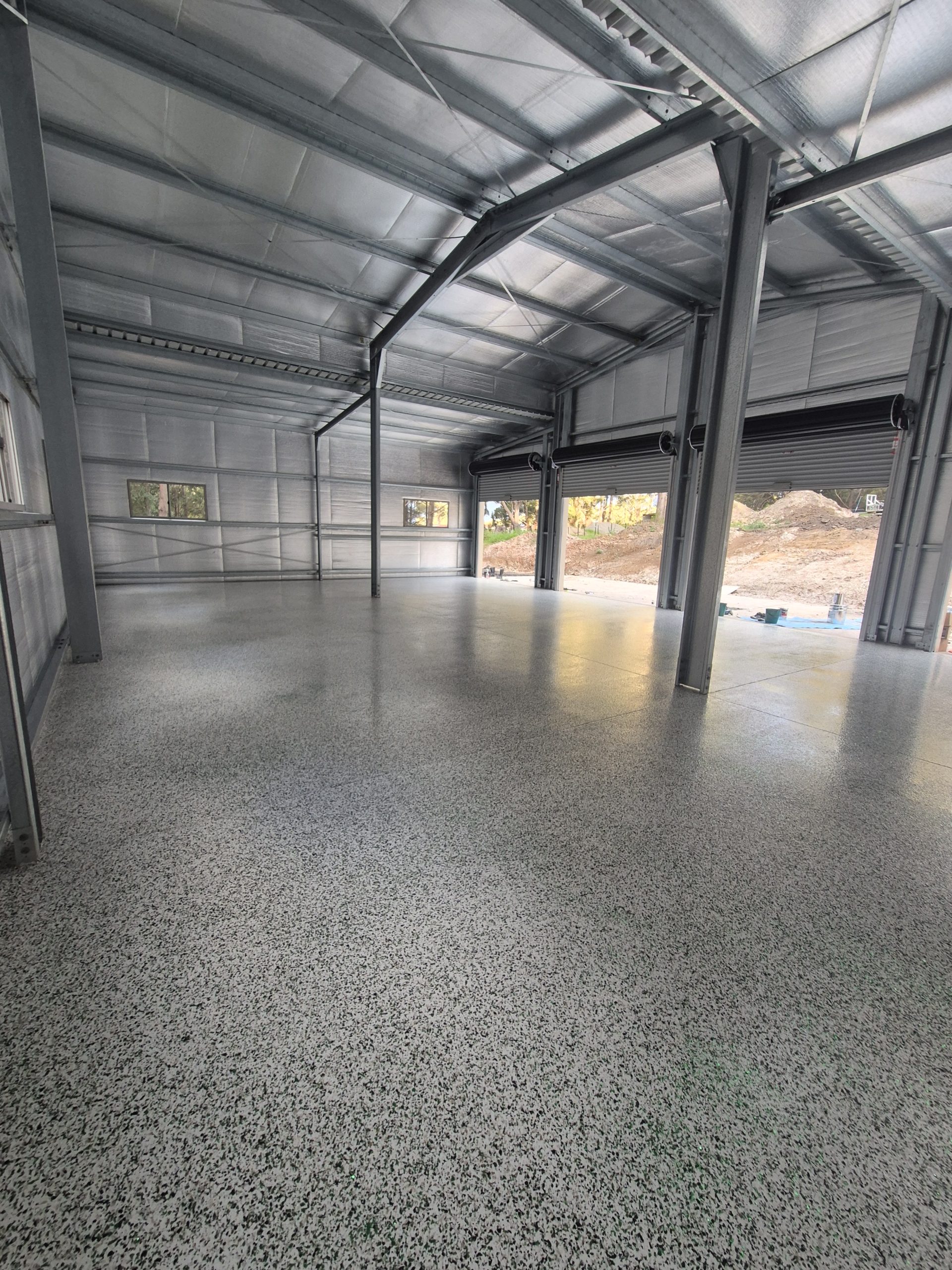 Close-up of diamond grinding concrete floor preparation in an Ulladulla workshop.