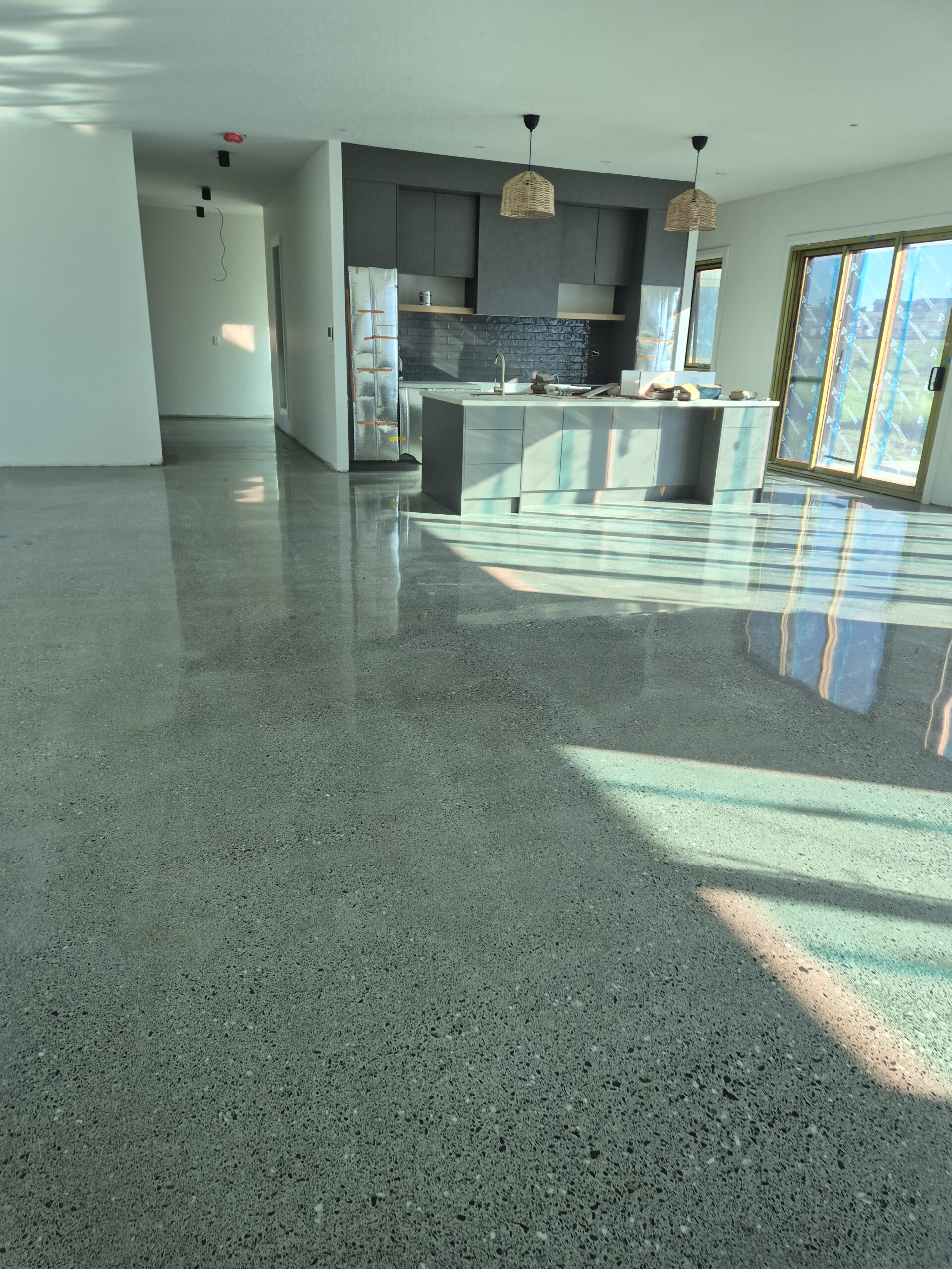 20260624_143551 Commercial grind and seal concrete flooring inside a busy Wollongong retail shop with a slip-resistant matte finish.