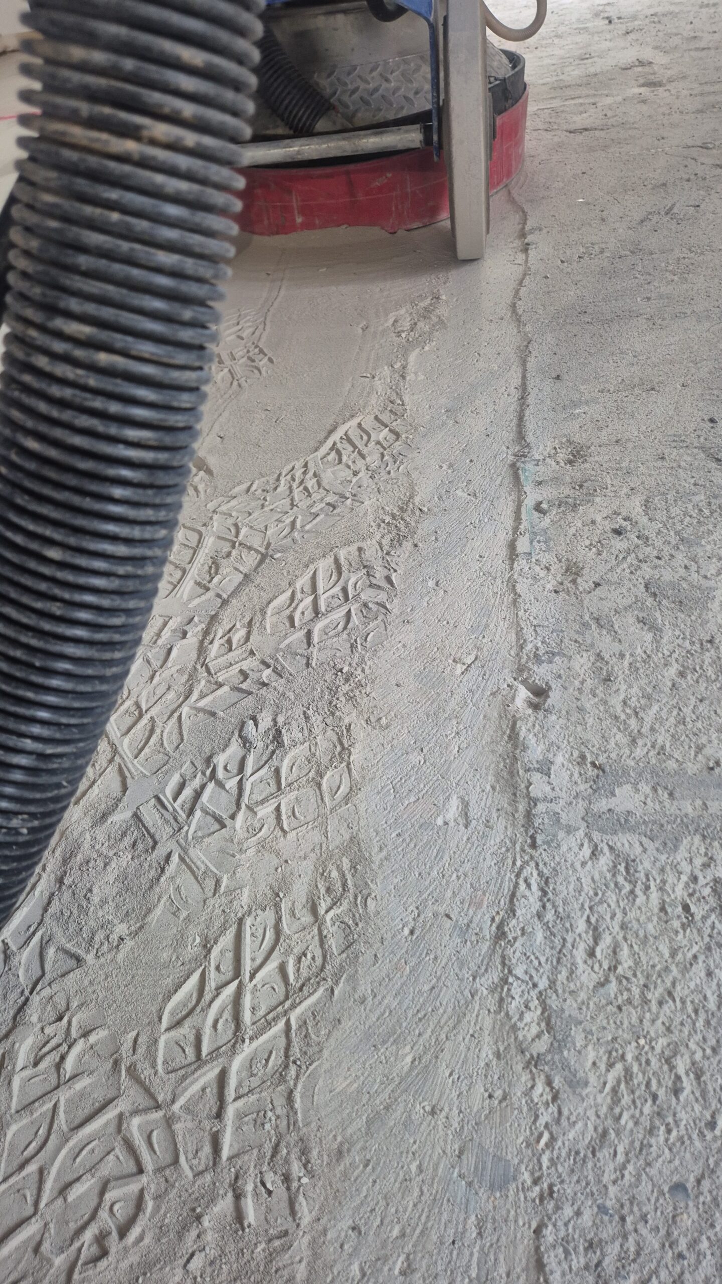 Close-up of diamond grinding concrete floor preparation in an Ulladulla workshop.
