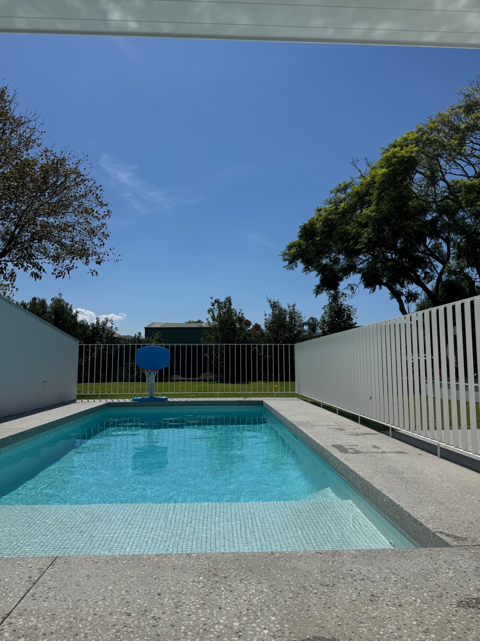 honed-concrete-pool-gerringong.jpg Modern rectangular swimming pool with light grey honed concrete paving and coping in Gerringong.