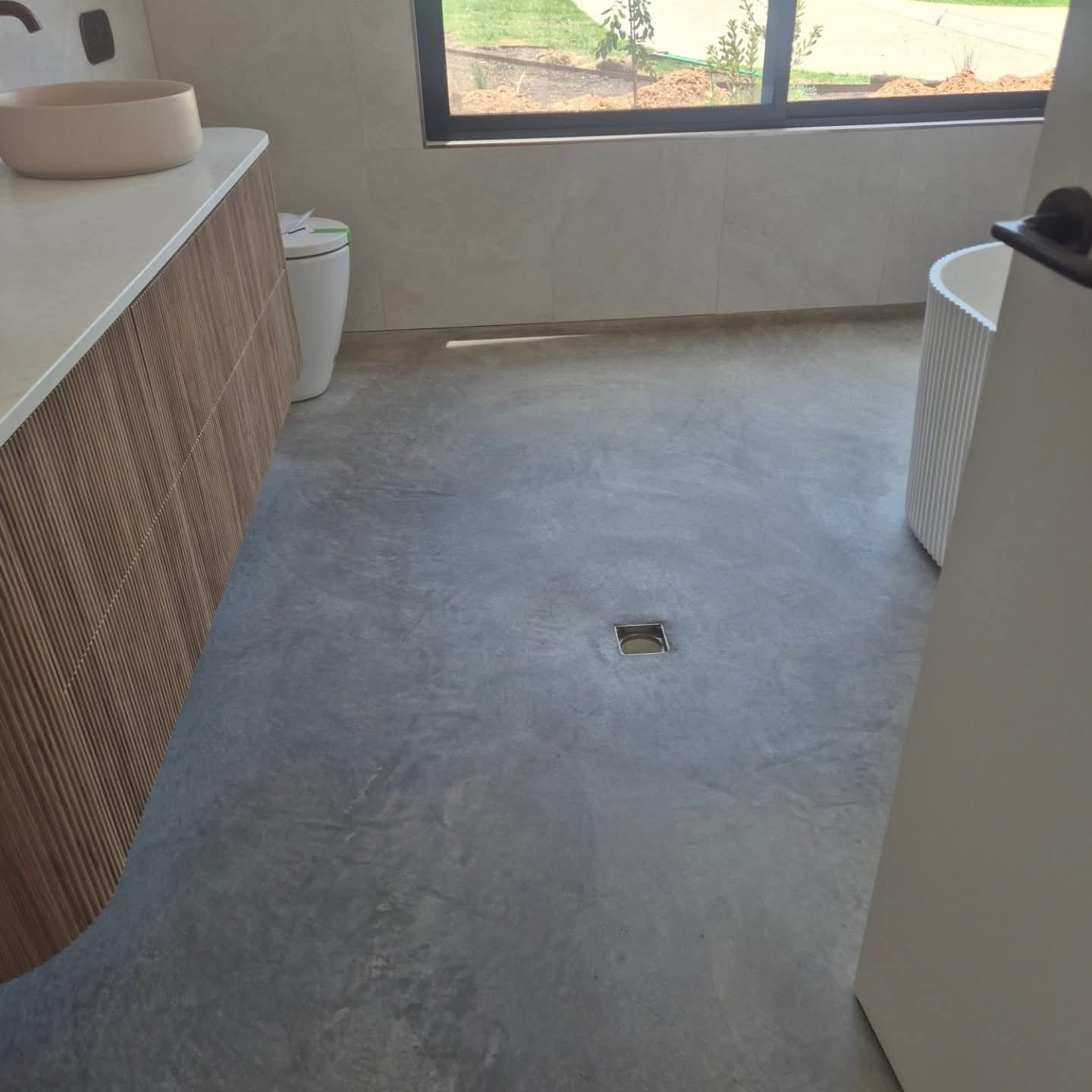 Matt burnished concrete floor finish with an architectural low-sheen matte look, showcasing natural trowel marks and slab character for a premium residential interior design project in Ulladulla by ProSand.
