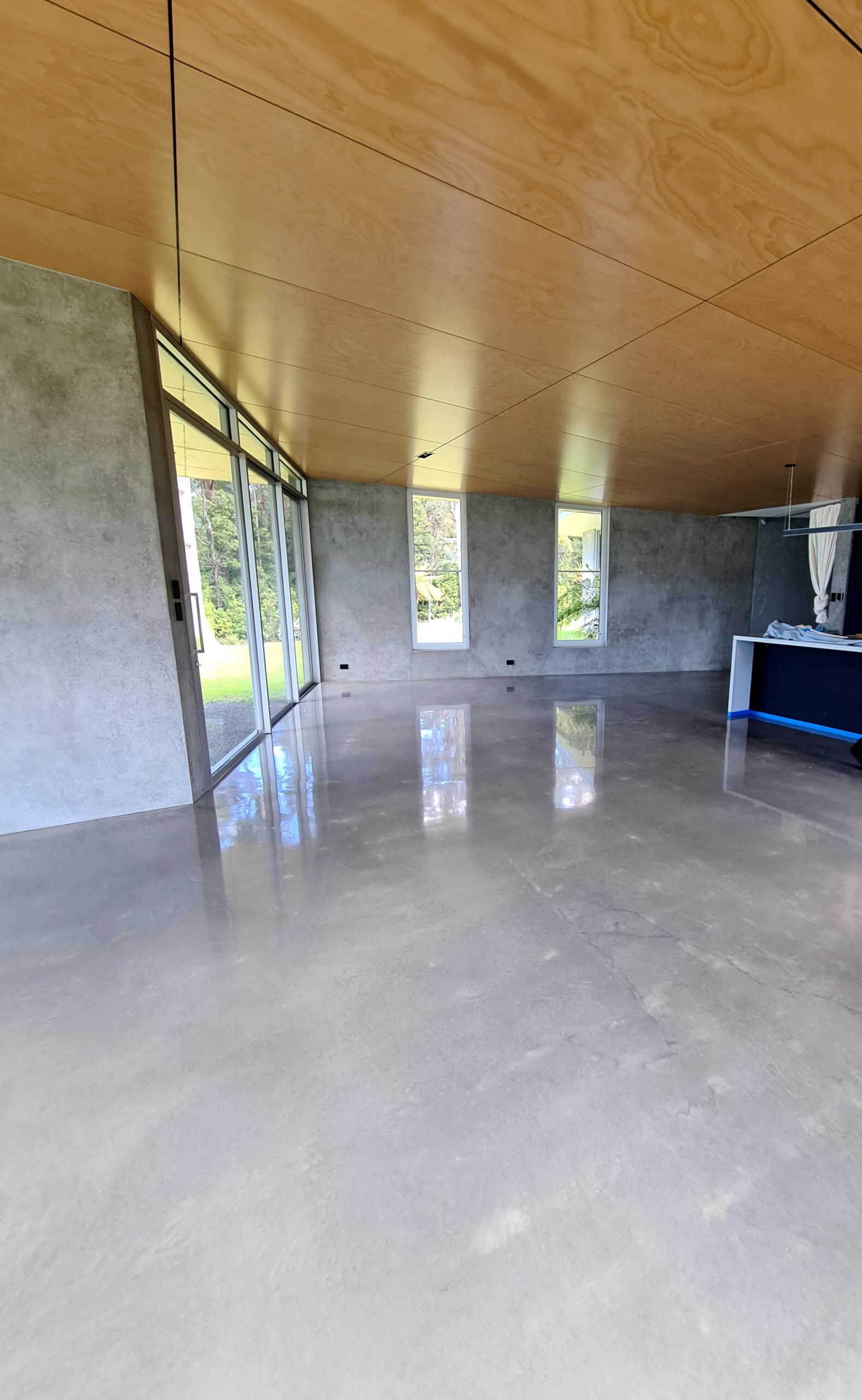 High-gloss burnished concrete floor showcasing natural trowel movement on a coastal property in Berry NSW by ProSand Polished Concrete.