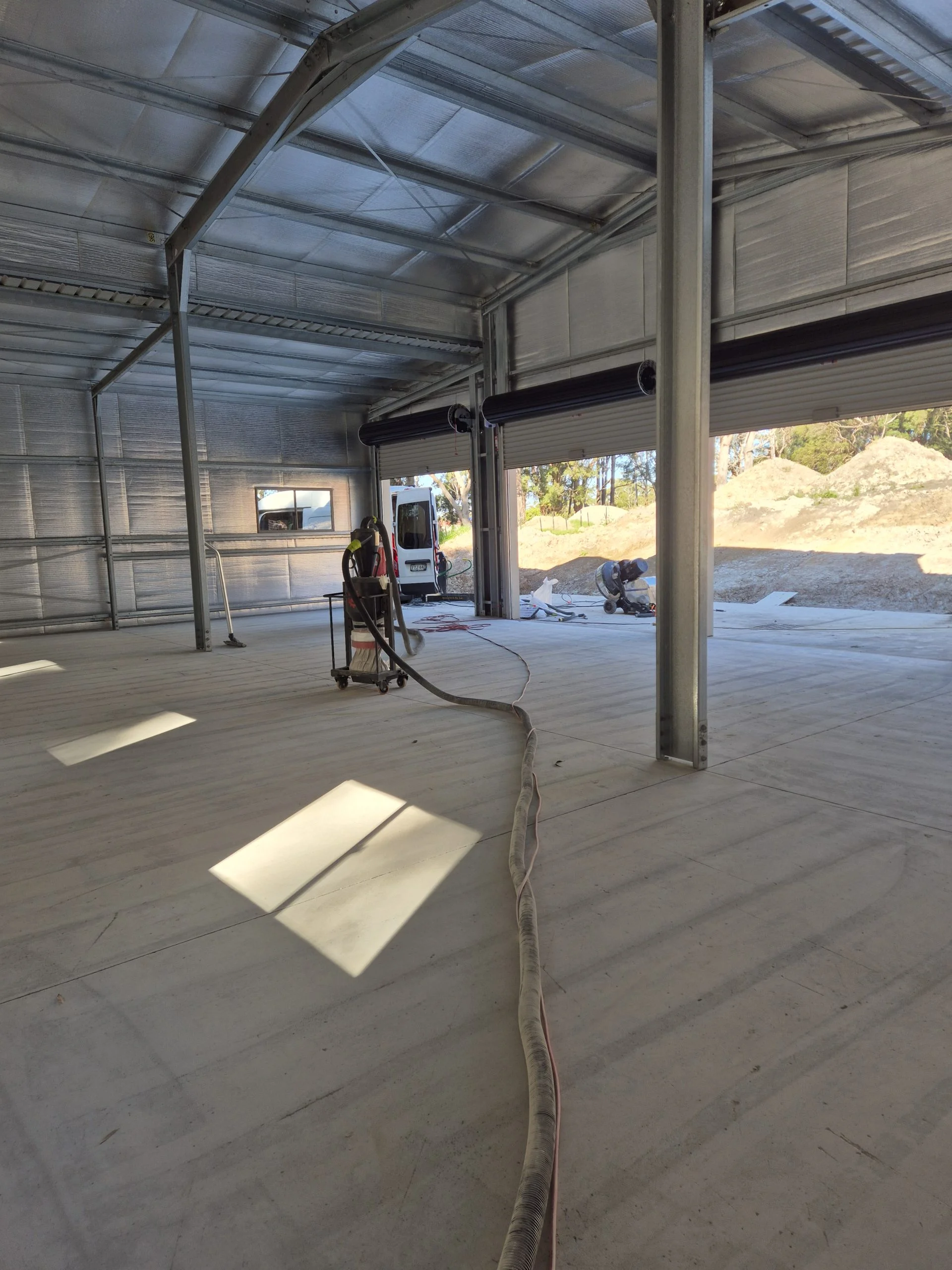 Close-up of diamond grinding concrete floor preparation in an Ulladulla workshop.