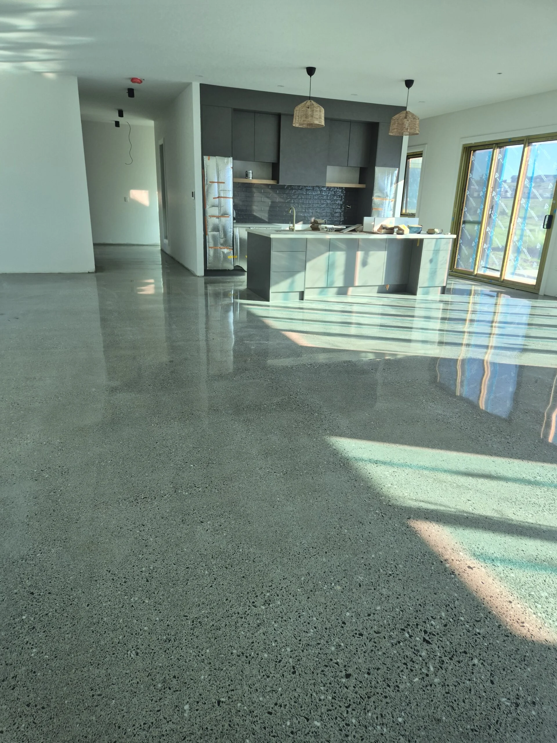 Close-up of diamond grinding concrete floor preparation in an Ulladulla workshop.